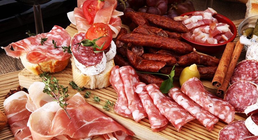 Food tray with delicious salami pieces of sliced ham sausage tomatoes salad and vegetable - Meat platter with selection - Cutting sausage and cured meat