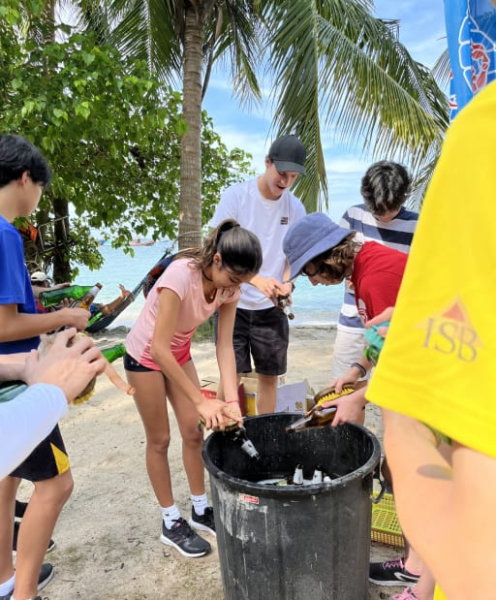 Students cleaning up garbage on a beach clean-up